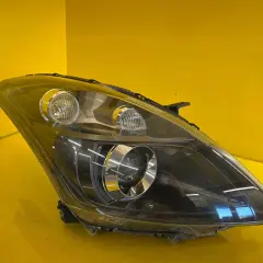 Przednia lampa do Suzuki Swift, z czarnym wnętrzem i chromowanymi elementami, gotowa do montażu.