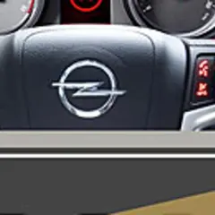 Kierownica Opla z przyciskami i logo. Warto zajrzeć do opel instrukcja obsługi, by poznać ich funkcje.
