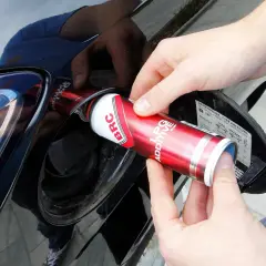 Ręce wlewają dodatek do LPG z puszki BRC do baku samochodu, dbając o czyszczenie wtrysków lpg.