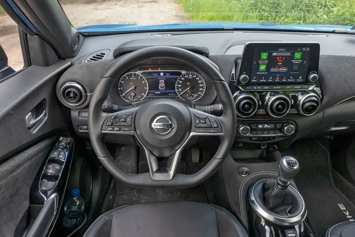 Nissan Juke deska rozdzielcza: kierownica, zegary, ekran multimediów, nawiewy i dźwignia zmiany biegów.
