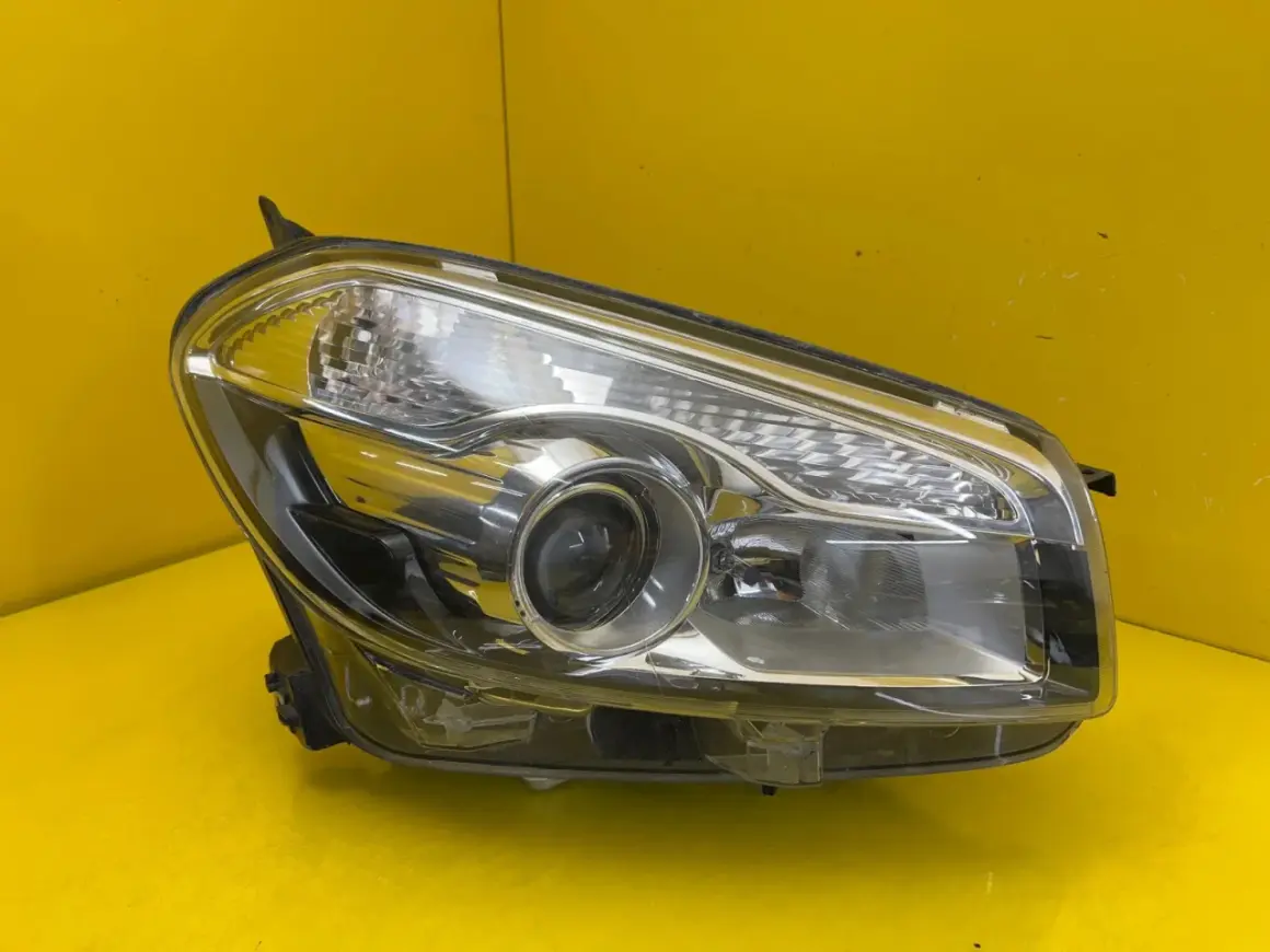 Przednia lampa Nissan Qashqai, gotowa do montażu, z wyraźnym kloszem i soczewką.